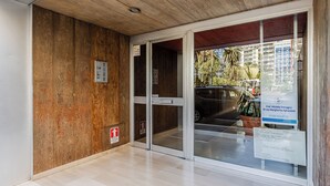 A modern building entrance with a wooden wall, a glass door, and a sign indicating a medical facility. - Il Pumo - Apulian Rooms Bari Moro 61 (Bari)