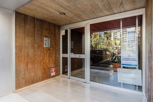 Une entrée moderne, avec un mur en bois, une porte en verre et une enseigne indiquant un établissement médical.