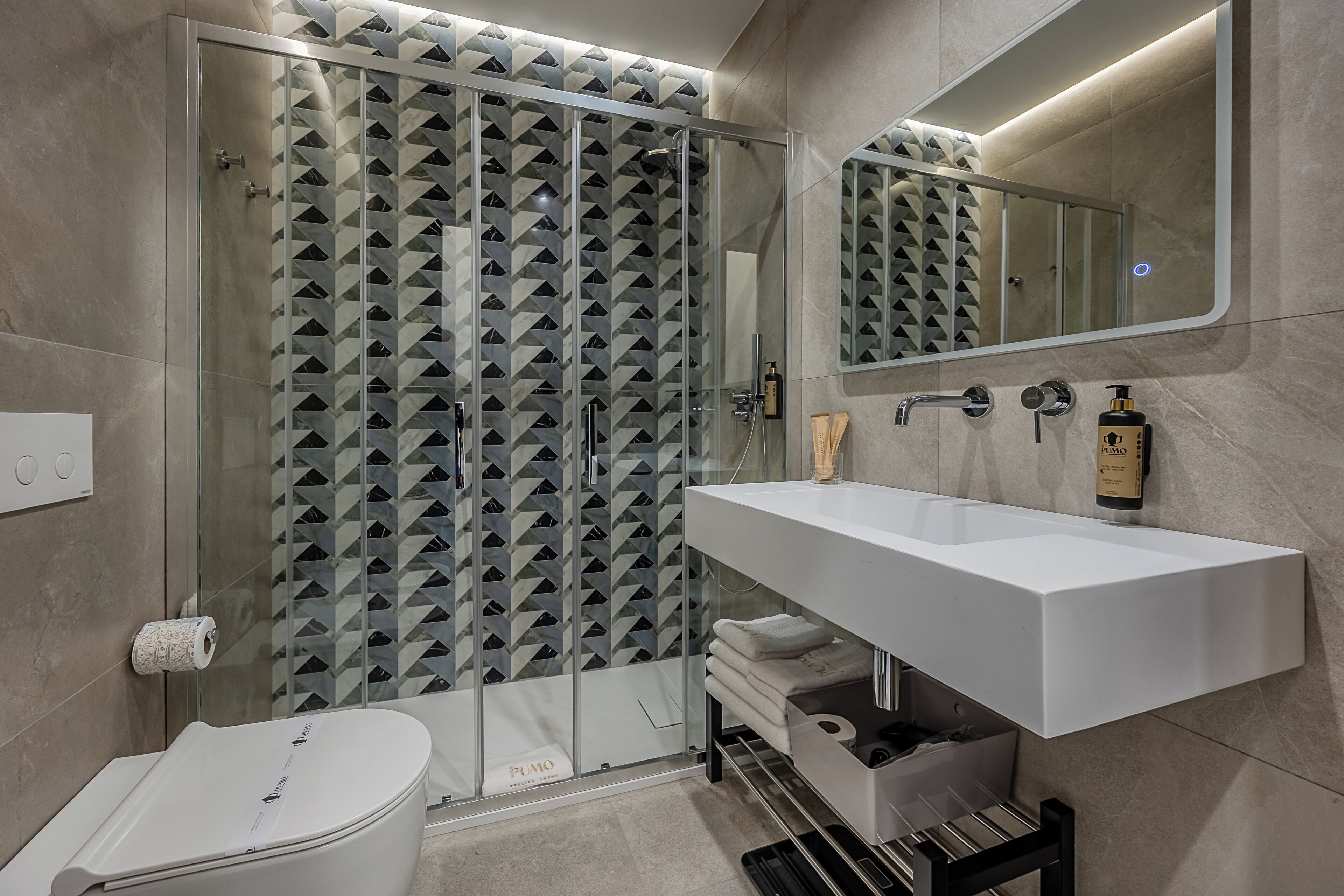 A modern bathroom with a glass shower enclosure, a white sink, and a mirror above it.