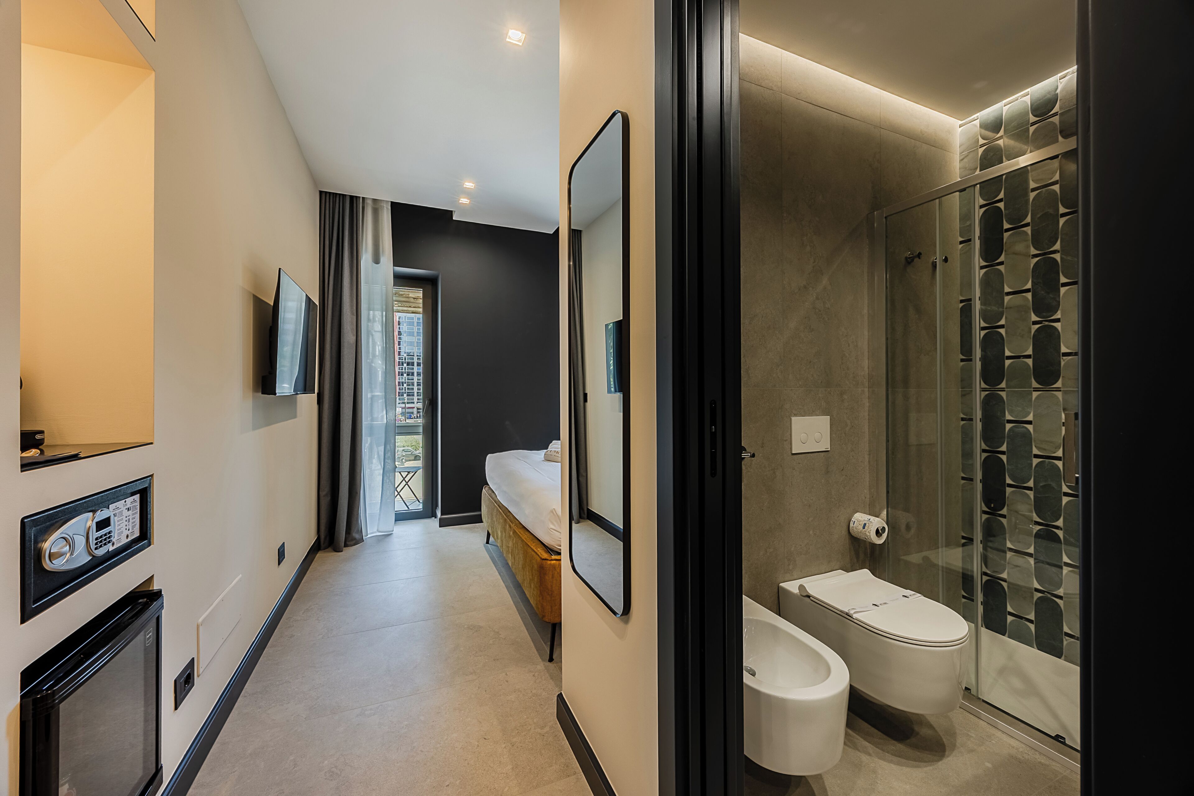 Un bagno moderno con box doccia in vetro, un water e un bidet.