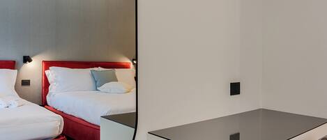 A hotel room with a bed, a desk, and a chair.