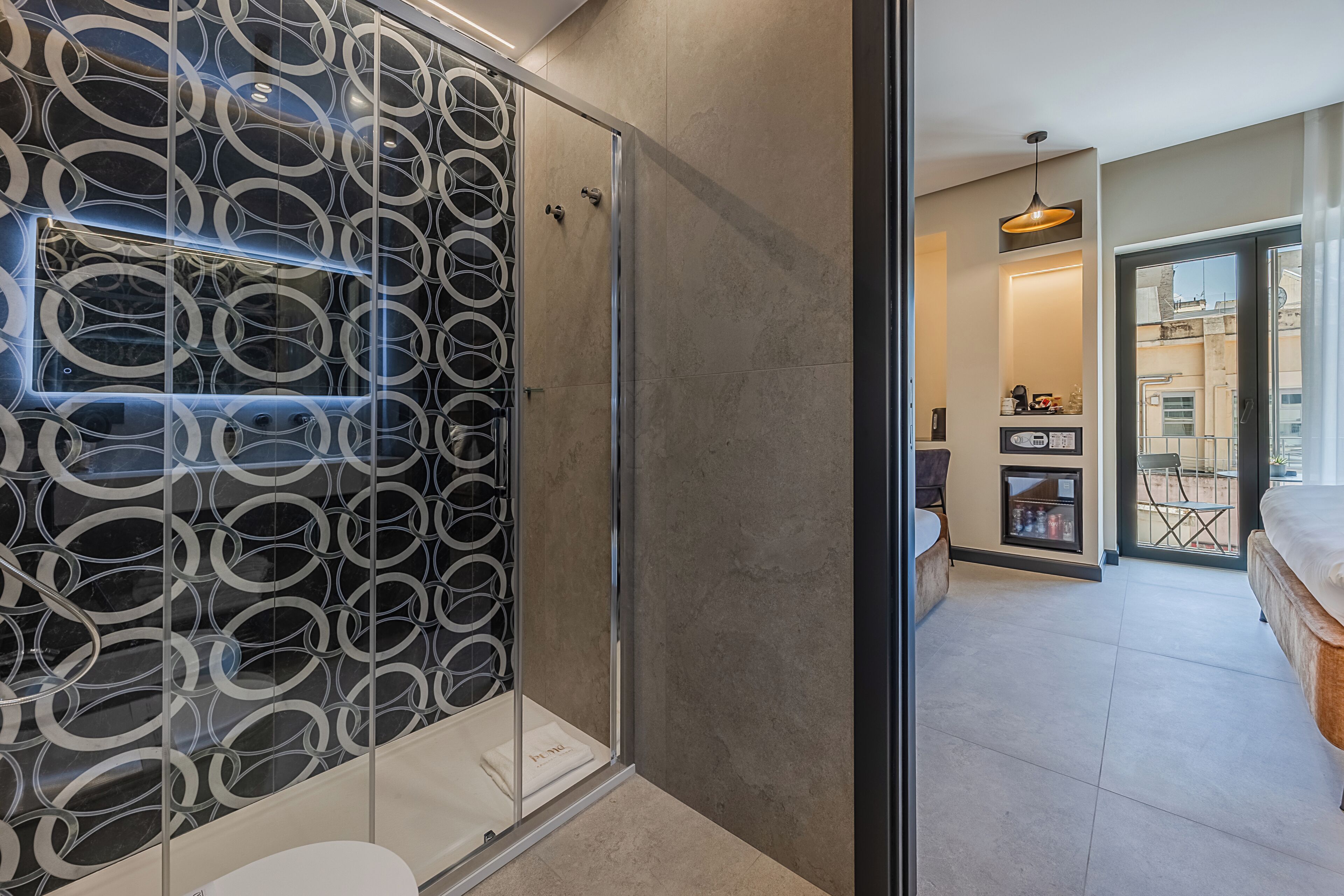 Ein modernes Badezimmer mit Duschkabine aus Glas und einer Wand mit Muster.