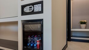 A minibar with a refrigerator containing bottled water and a can of Coca-Cola. - Il Pumo - Apulian Rooms Bari Moro 61 (Bari)