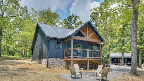 A two-story cabin with a stone foundation, a balcony with outdoor seating, and a metal roof. - Family & Pet Friendly! Murray Cabin w/ Lake Access (Murray)