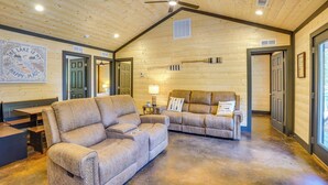 A spacious room with two sofas, a ceiling fan, and a large window. - Family & Pet Friendly! Murray Cabin w/ Lake Access (Murray)