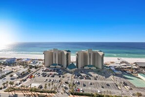 A beachfront hotel with multiple high-rise buildings, a parking lot, and a clear view of the ocean. - Laketown Wharf 1817 (Panama City Beach)