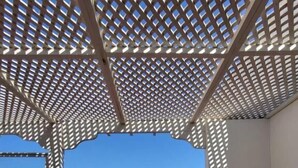 A covered outdoor area with a view of the sea, a patio with a table and chairs, and a wooden bench. - Dar janoub  (Moulay Bouzarqtoune)