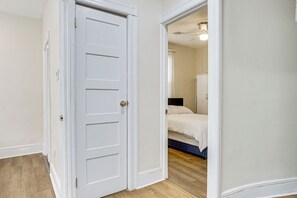 A white door leading to a bedroom with a bed and a ceiling fan. - Near NYC Transit! Modern Gateway Region Apt (West New York)