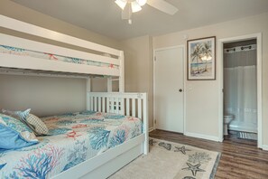 A bedroom with a bunk bed, a door leading to a bathroom, and a beach-themed rug. - Walk to Beach: Harbor Island Condo w/ Deck (Harbor Island)