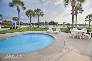 A swimming pool with a shallow water warning sign, lounge chairs, and palm trees. - Walk to Beach: Harbor Island Condo w/ Deck (Harbor Island)