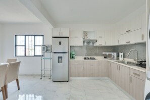 A modern kitchen with a refrigerator, stove, sink, and a window. - Stylish & Spacious Unit w/ Deck in Cuernavaca (Cuernavaca)