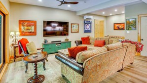 A living room with a sofa, a coffee table, a television, and a ceiling fan. - Walk to Blue Ridge Parkway! Family Home w/ Hot Tub (Blowing Rock)