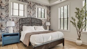 A bedroom with a bed, nightstands, a potted plant, and a window with blinds. - Pool Access! Centrally Located ATL Escape w/ Deck (Atlanta)