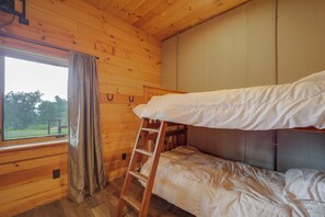 A bunk bed room with a wooden ladder, a window with curtains, and a view of greenery outside. - 66-acre Group Escape! Gateway to Grandfather Mtn (Elk Park)