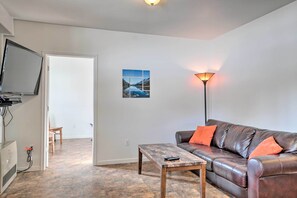 A living room with a leather sofa, a coffee table, a TV, and a lamp. - Northern Lights View! 2-unit 'fitz Creek Retreat' (Homer)