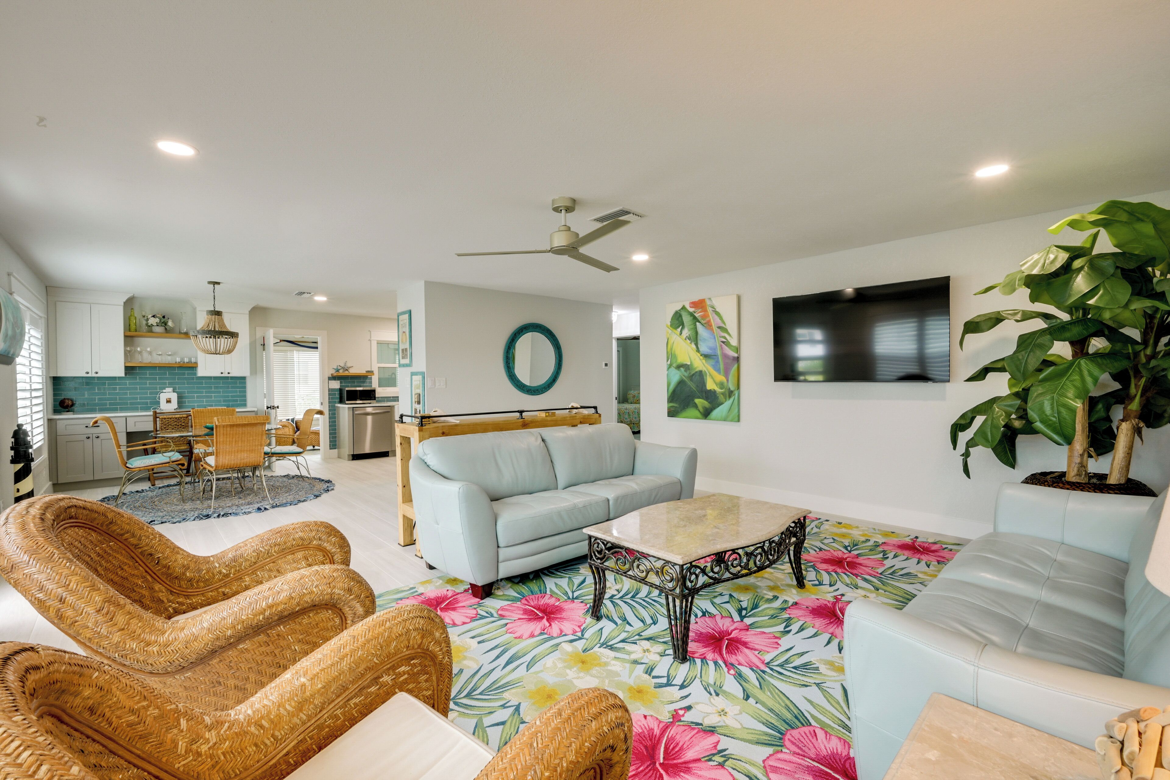 A modern living room with a sofa, a coffee table, and a dining area with chairs and a table.