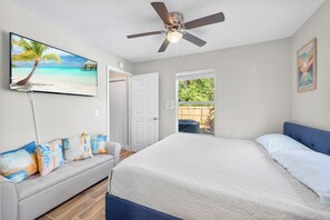 A bedroom with a bed, a ceiling fan, a TV on the wall, and a door leading to a balcony. - 13 Mi to Beach! Family-friendly Palm Bay Retreat (Palm Bay)