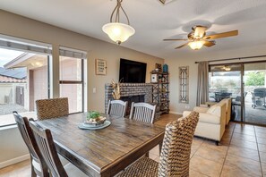 Ein Essbereich mit Holztisch, Stühlen und Kamin.