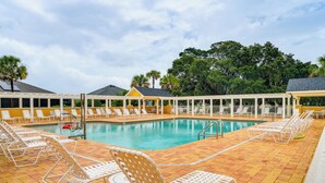 A pool area with lounge chairs and a clear view of the pool. - Community Pools, Golf & More! Home in The Villages (Wildwood)