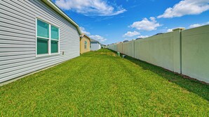 A row of single-story houses with a grassy lawn in between. - Community Pools, Golf & More! Home in The Villages (Wildwood)