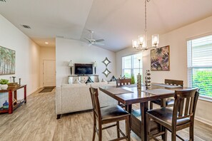 A spacious living area with a dining table, chairs, a sofa, a television, and a ceiling fan. - Community Pools, Golf & More! Home in The Villages (Wildwood)