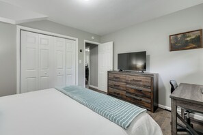 A bedroom with a bed, a dresser, a television, and a painting on the wall. - Rolling Hills Retreat, Cozy 2BR Near Lakes/smokies (Morristown)