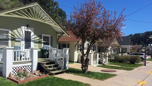 A residential area with houses, a sidewalk, and a tree.