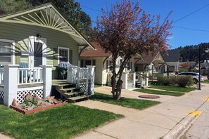 A residential area with houses, a sidewalk, and a tree.