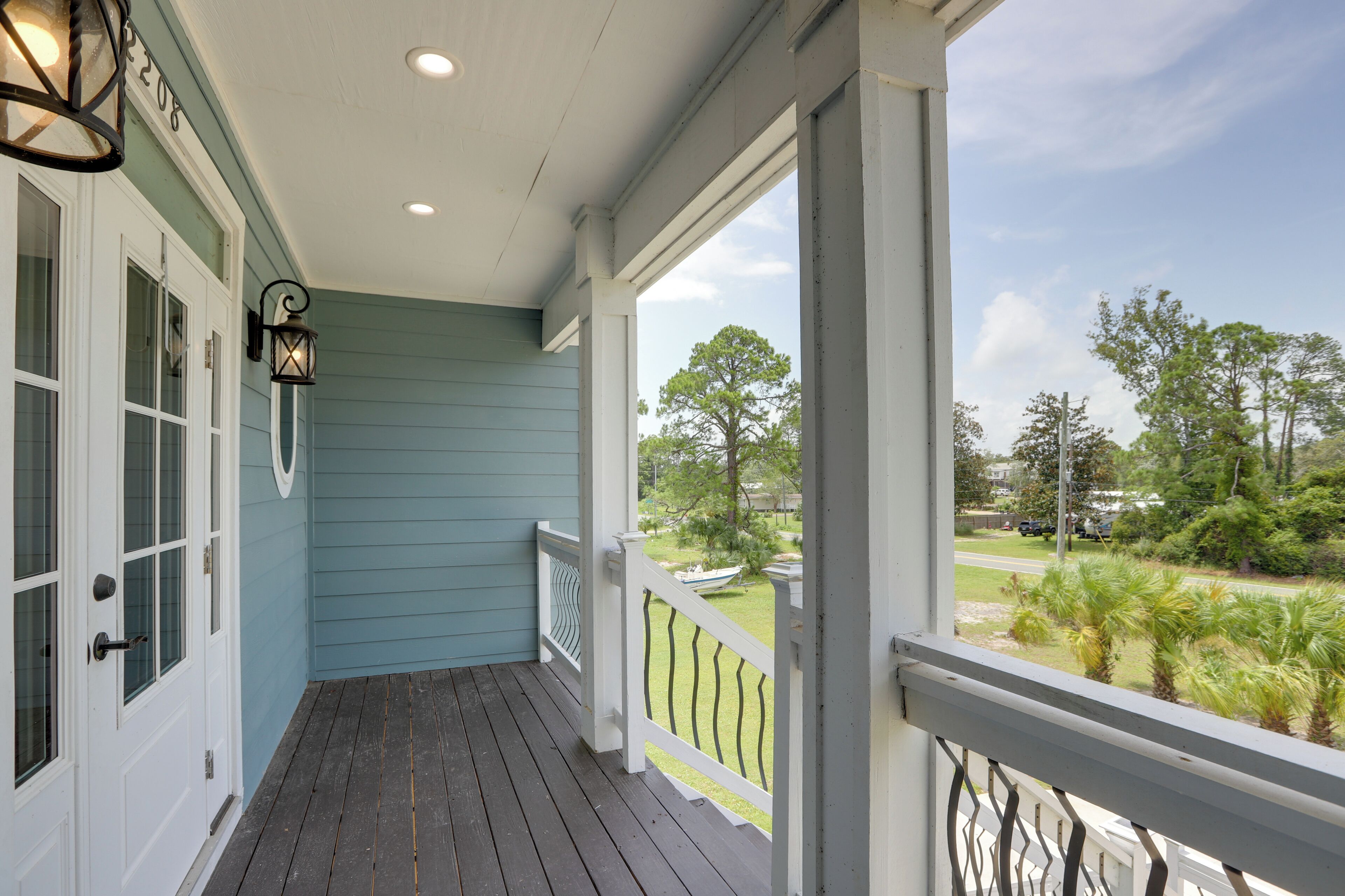 A porch with a view of a grassy area and trees.