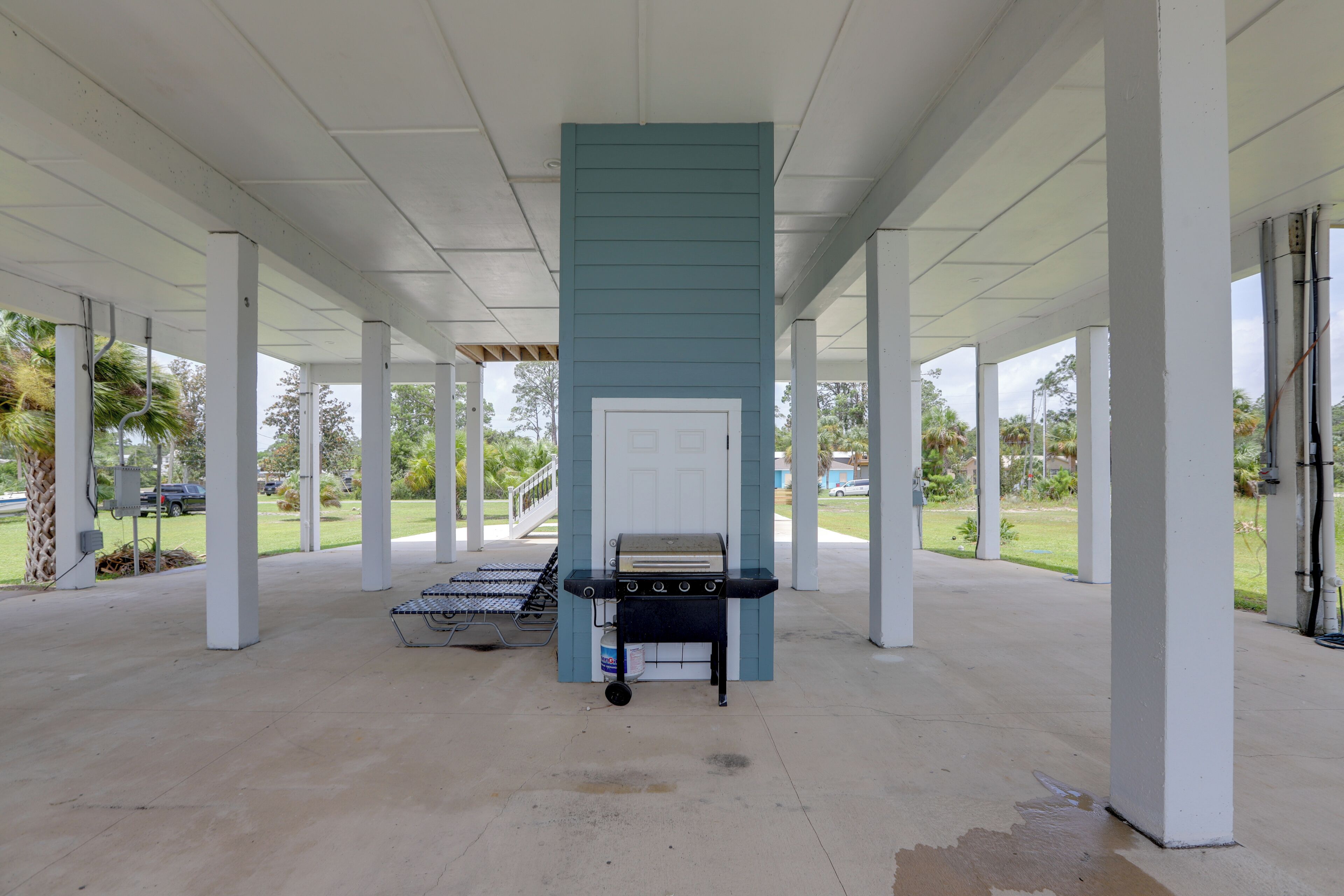 A covered outdoor area with a grill and seating.