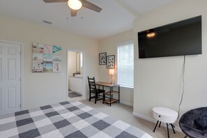 A room with a checkered floor, a dining table with chairs, a television mounted on the wall, and artwork on the walls. - Waterfront Family Home w/ Views in Carrabelle (Carrabelle)