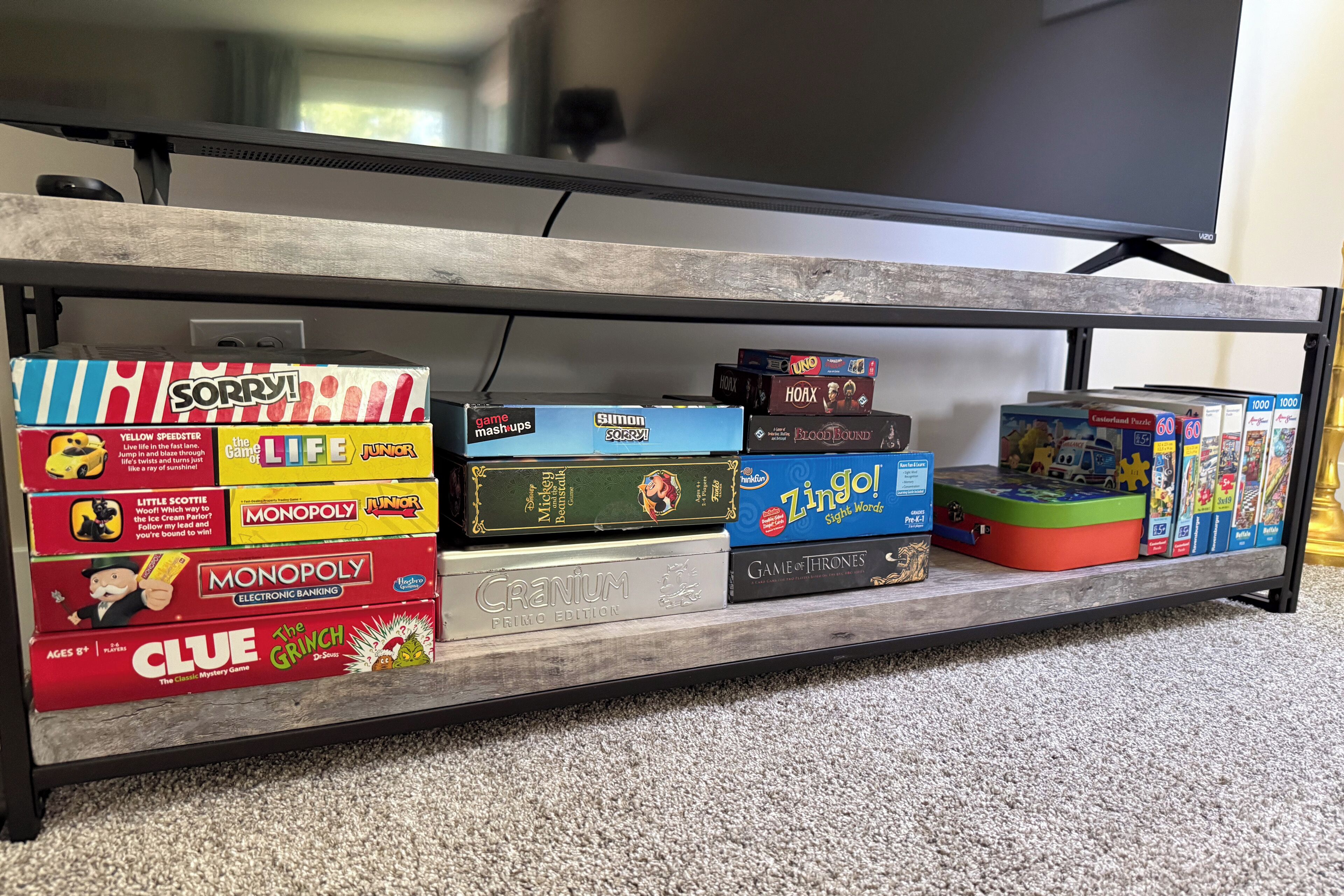 A shelf with various board games and a television.
