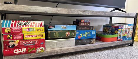 A shelf with various board games and a television.