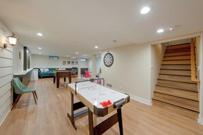Amplia sala de estar con mesa de fútbol, dardos y un sofá.
