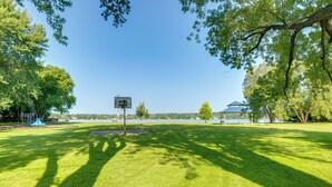 Un parco con un campo da basket, tavoli da picnic e un padiglione.