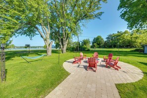 A paved patio area with Adirondack chairs and a hammock. - Walk to Beach! Mccullom Lake Family Getaway (McHenry)
