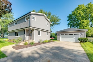 A two-story residential house with a garage, a front porch, and a well-maintained lawn. - Walk to Beach! Mccullom Lake Family Getaway (McHenry)