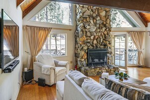 Una sala acogedora con chimenea de piedra, asientos cómodos y ventanas amplias.