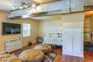 A child's bedroom with a bunk bed, a desk, a dresser, and a bookshelf.