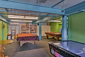 A room with a pool table, a billiards table, a bookshelf, and a small table with a red tablecloth. - Hike, Swim & Relax: Pine Mountain Club Escape! (Pine Mountain Club)