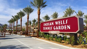 En skylt för Indian Wells Tennis Garden med en grind som utgör ingången.