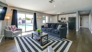Una sala de estar moderna con un sofá, una mesa de centro y vista a la piscina.