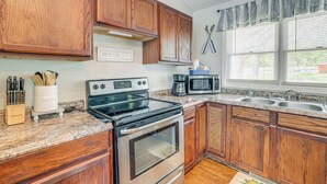 A kitchen with wooden cabinets, a stainless steel stove, a microwave, and a double sink. - 1 Mi to Table Rock Lake! Home w/ Water Views (Shell Knob)