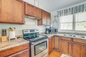 A kitchen with wooden cabinets, a stainless steel stove, a microwave, and a double sink. - 1 Mi to Table Rock Lake! Home w/ Water Views (Shell Knob)
