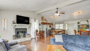 A spacious living room with a fireplace, a large sofa, a coffee table, and a television. - 1 Mi to Table Rock Lake! Home w/ Water Views (Shell Knob)