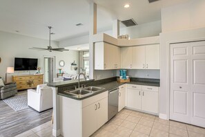 A modern kitchen with white cabinets, a granite countertop, and a built-in dishwasher. - 8 Mi to Englewood Beach! Canal-front Family Haven (Rotonda West)