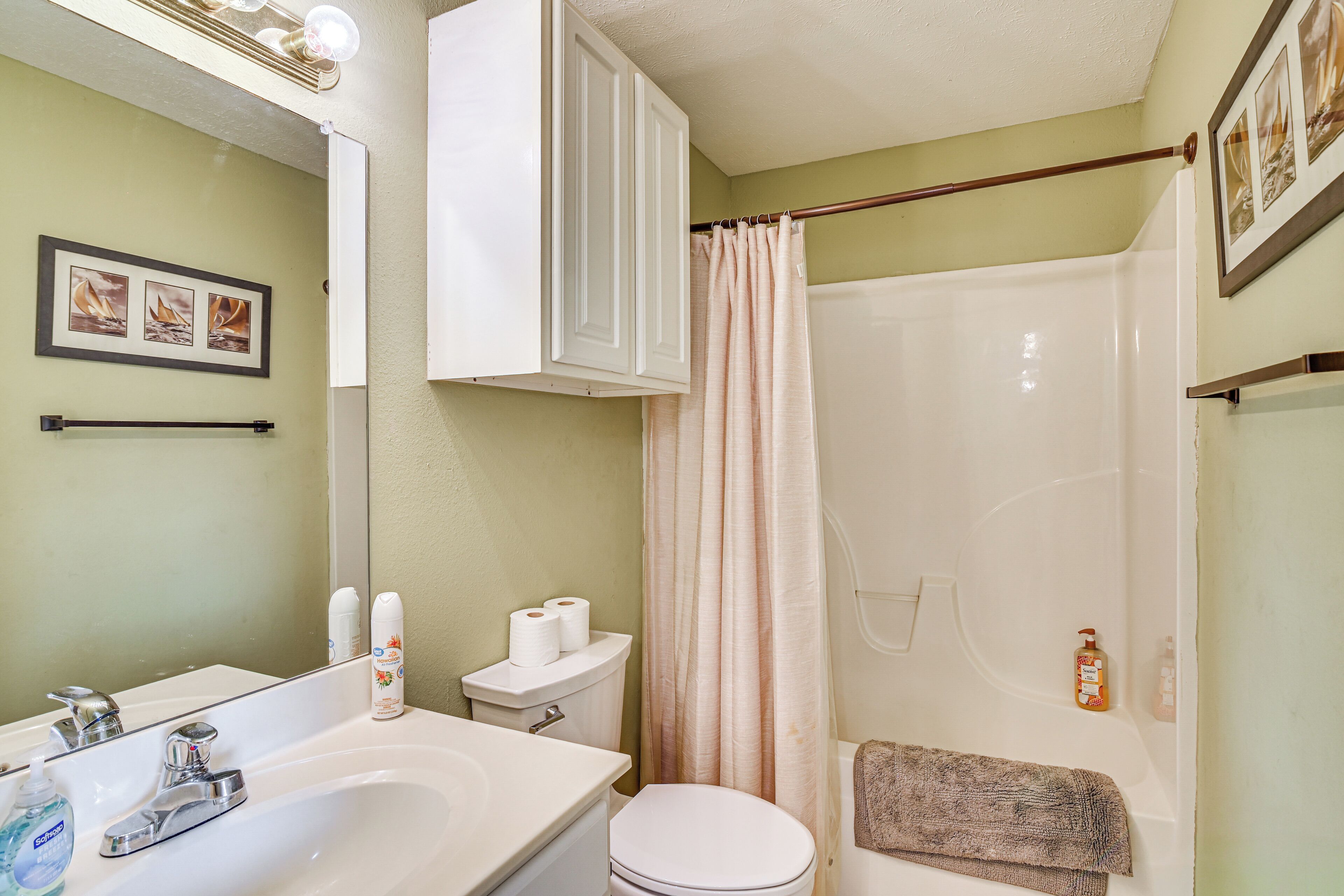 A bathroom with a sink, toilet, and shower.