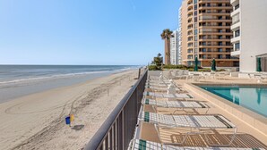 A beachside hotel with a pool, sun loungers, and a view of the ocean. - Dream Daytona Getaway: Beachfront Condo! (Daytona Beach Shores)