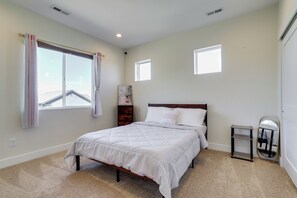 A bedroom with a bed, a nightstand, a mirror, and a window. - Updated Family Home w/ Patio in Brighton (Brighton)