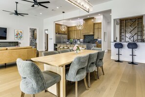 Una cocina moderna con armarios de madera, un refrigerador de acero inoxidable y una encimera de mármol.